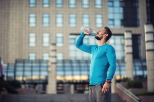 man drinking water in city scape